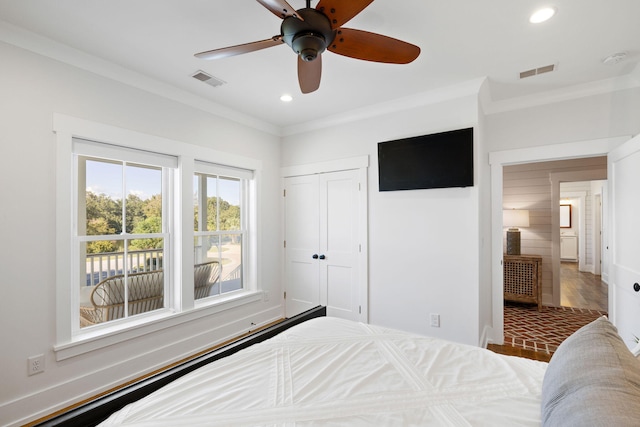 bedroom with ceiling fan, a closet, hardwood / wood-style floors, and ornamental molding