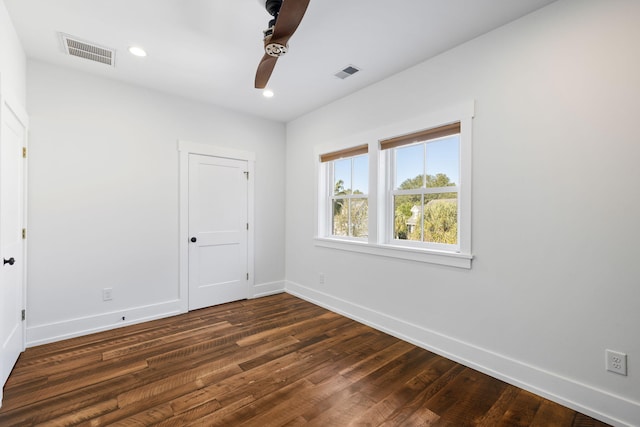 unfurnished room with dark hardwood / wood-style flooring and ceiling fan