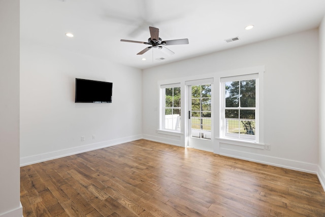 empty room with ceiling fan and hardwood / wood-style flooring