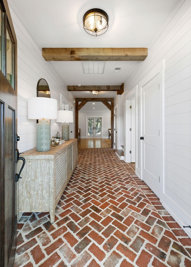 corridor with wooden walls and beam ceiling