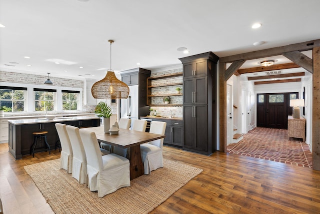 dining room with beam ceiling and hardwood / wood-style flooring