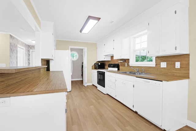 kitchen with white appliances, backsplash, sink, light wood-type flooring, and white cabinets