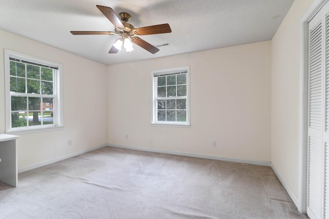 unfurnished bedroom with multiple windows, ceiling fan, and light carpet