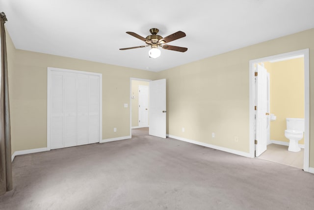 unfurnished bedroom featuring light colored carpet, ceiling fan, ensuite bath, and a closet