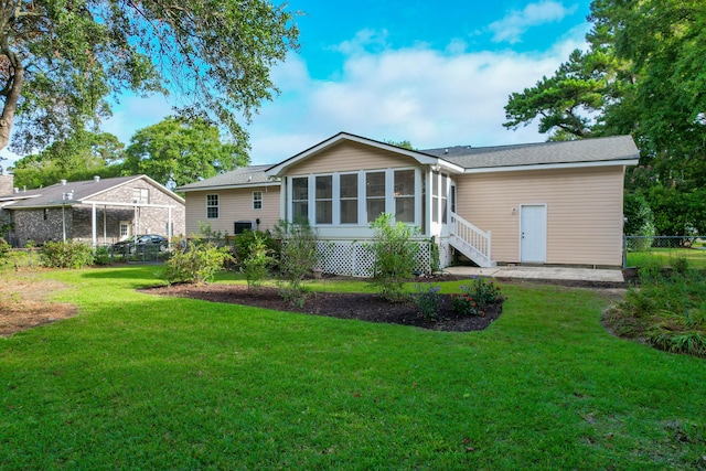 back of property featuring a sunroom and a yard