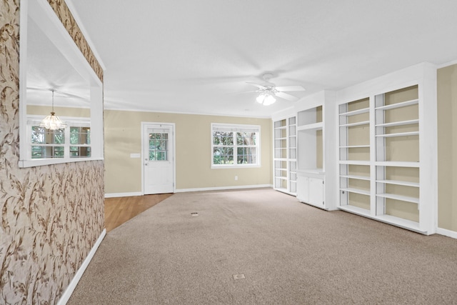 empty room with hardwood / wood-style floors and ceiling fan with notable chandelier