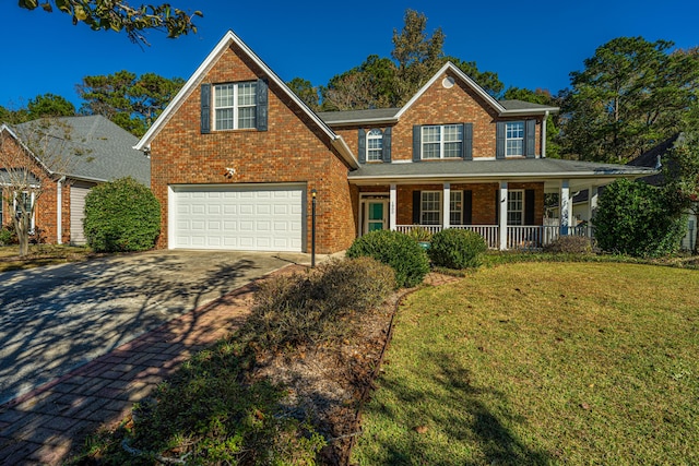 view of front of house with covered porch, a garage, and a front yard