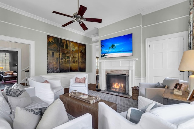 living room with ornamental molding, a fireplace, and ceiling fan