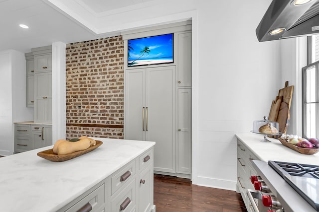 kitchen featuring brick wall, dark wood-type flooring, white cabinetry, and range