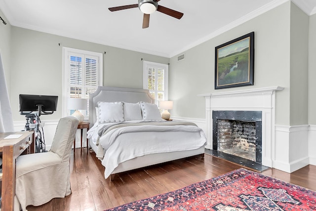 bedroom with ornamental molding, dark wood-type flooring, and ceiling fan