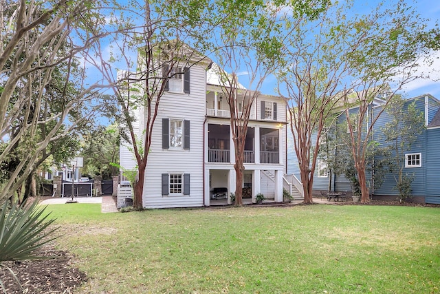 back of property with a yard, a patio area, and a sunroom