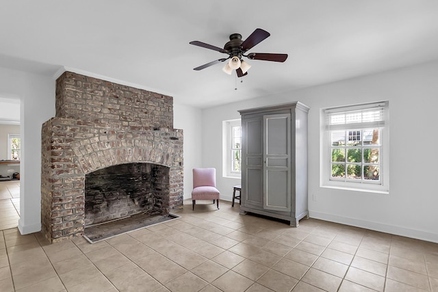 unfurnished living room featuring ceiling fan, light tile patterned flooring, and a fireplace