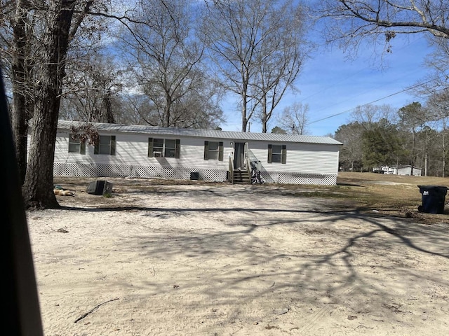 manufactured / mobile home featuring metal roof and driveway