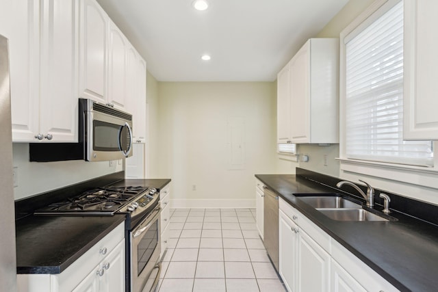 kitchen featuring appliances with stainless steel finishes, light tile patterned flooring, sink, and white cabinets