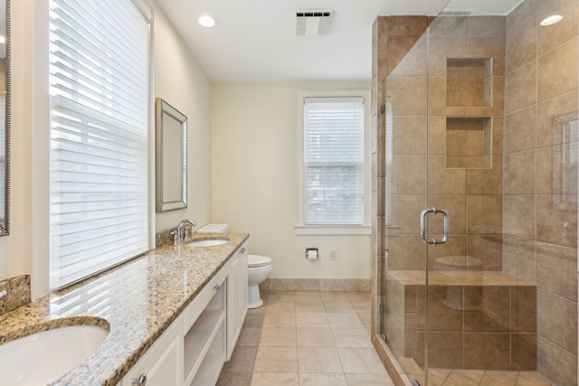 bathroom featuring vanity, toilet, an enclosed shower, and tile patterned floors