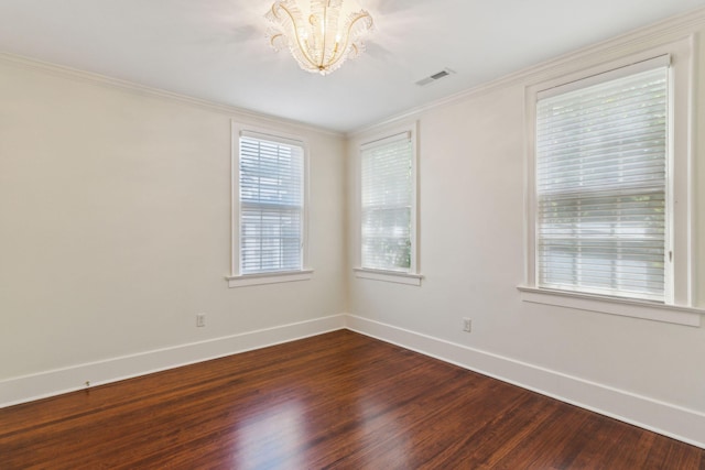 spare room with wood-type flooring, a chandelier, and ornamental molding