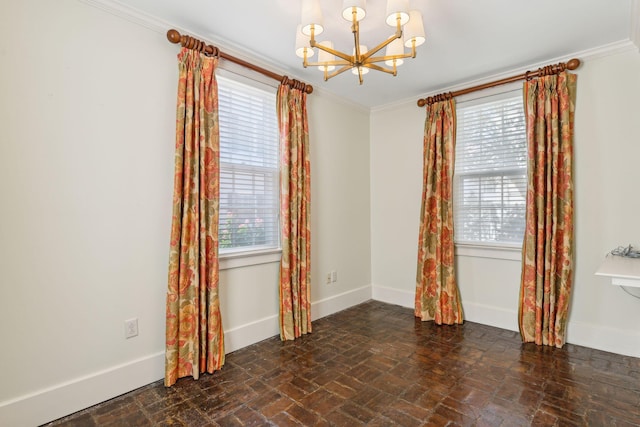 empty room featuring ornamental molding and a chandelier