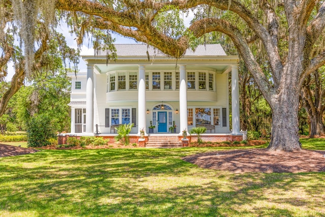 neoclassical home with a front lawn and a porch