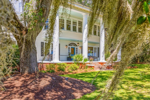 neoclassical home with a front yard and covered porch