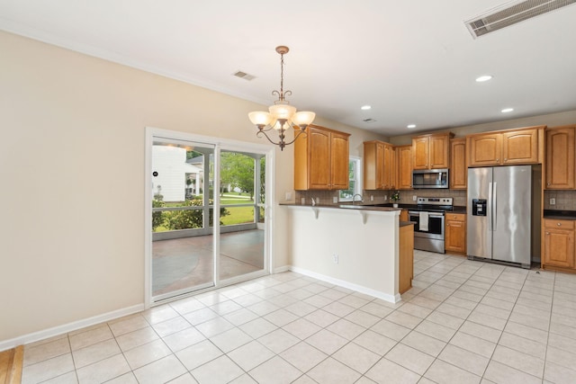 489 Dolphin Dr, Summerville, SC 29485 - kitchen with stainless steel appliances, dark countertops, decorative backsplash, a chandelier, and a peninsula
