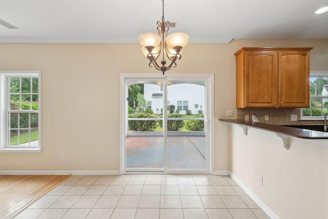 489 Dolphin Dr, Summerville, SC 29485 - unfurnished dining area featuring a chandelier, crown molding, and baseboards