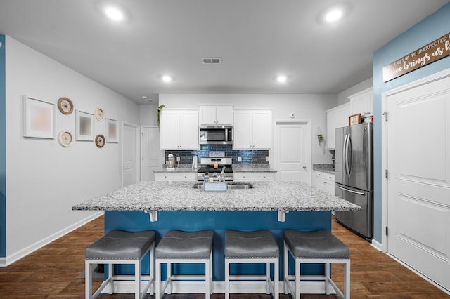 671 Silver Spruce St, Summerville, SC 29486 - kitchen featuring appliances with stainless steel finishes, white cabinets, a kitchen bar, recessed lighting, and decorative backsplash