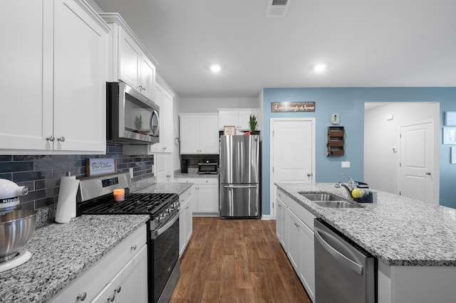 671 Silver Spruce St, Summerville, SC 29486 - kitchen with appliances with stainless steel finishes, a sink, white cabinets, dark wood-type flooring, and tasteful backsplash