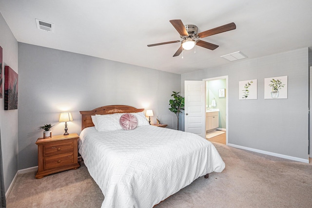 bedroom with ceiling fan, light colored carpet, and connected bathroom