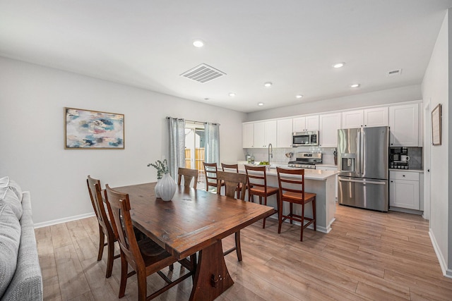 dining space featuring light hardwood / wood-style flooring and sink