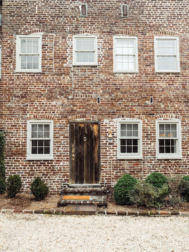 doorway to property featuring brick siding