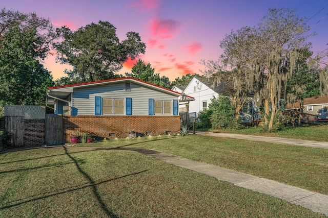 view of front of home with fence, a front yard, and brick siding