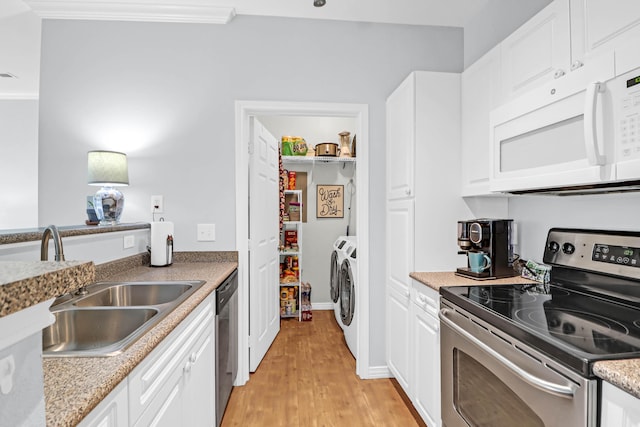 kitchen with washing machine and dryer, stainless steel appliances, white cabinetry, and light hardwood / wood-style floors