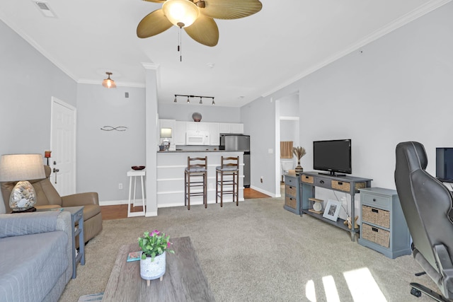 living room with light carpet, ceiling fan, track lighting, and ornamental molding