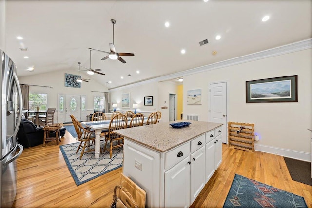 1604 Jungle Rd, Edisto Island, SC 29438 - kitchen with stainless steel fridge, ceiling fan, white cabinetry, a center island, and crown molding