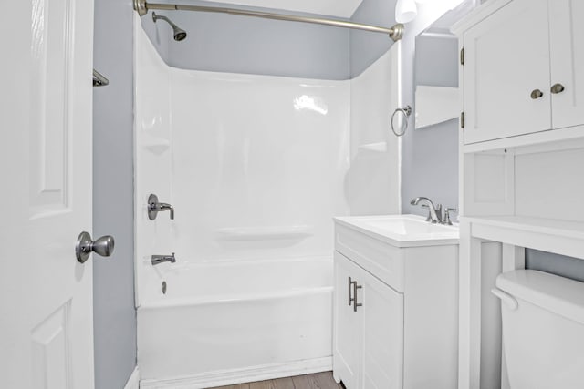 full bathroom featuring toilet,  shower combination, hardwood / wood-style floors, and vanity