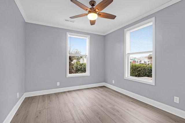 spare room featuring light hardwood / wood-style floors, ornamental molding, and a wealth of natural light