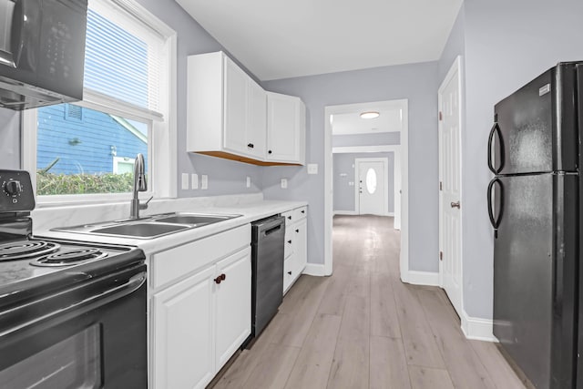 kitchen with black appliances, light hardwood / wood-style flooring, white cabinetry, and sink