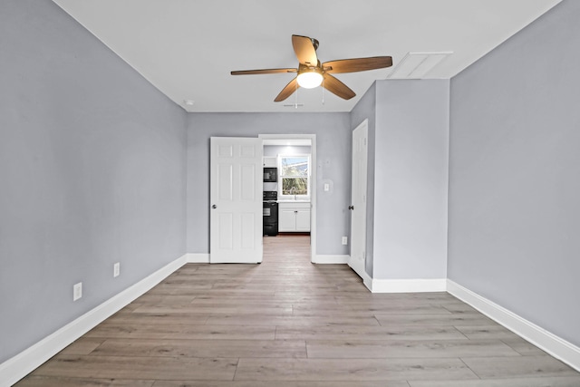 empty room featuring ceiling fan and light hardwood / wood-style flooring