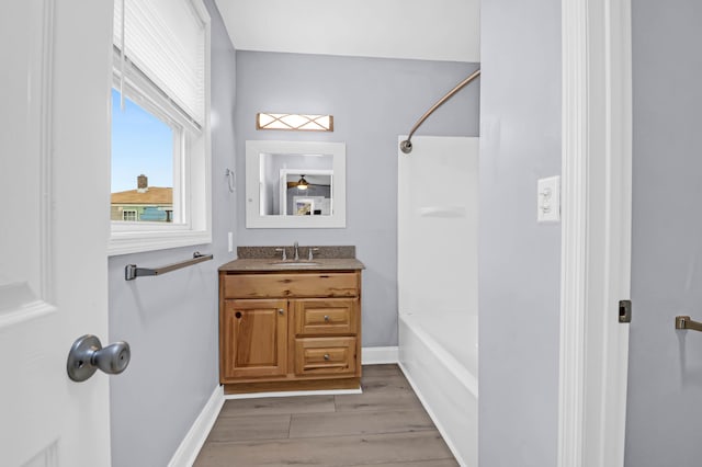 bathroom with bathtub / shower combination, wood-type flooring, and vanity