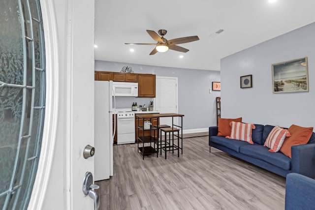 living room with light wood-type flooring and ceiling fan