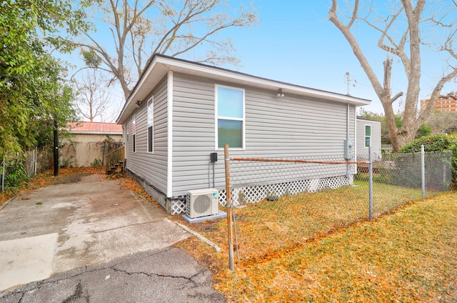 view of home's exterior with ac unit and a yard