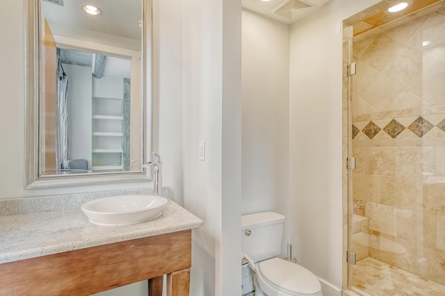 bathroom with vanity, toilet, and a shower with door