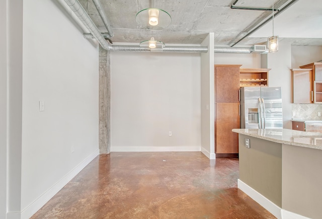 kitchen featuring light stone counters, concrete flooring, stainless steel fridge with ice dispenser, and hanging light fixtures