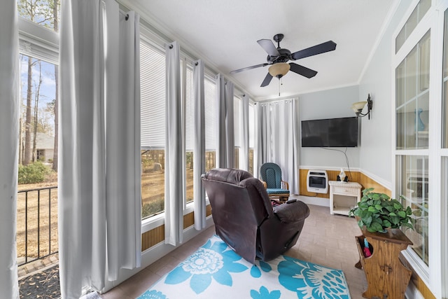 sunroom featuring heating unit and ceiling fan