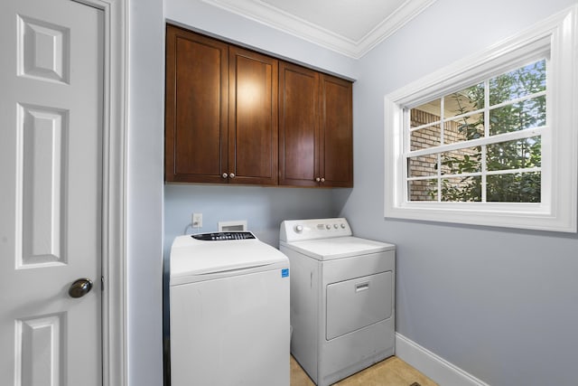 washroom with cabinets, ornamental molding, and washing machine and dryer