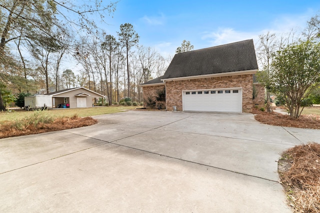 view of side of property with a garage and an outbuilding