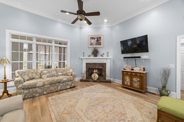 living room with crown molding, ceiling fan, a fireplace, and hardwood / wood-style floors