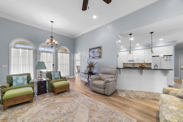 living room featuring crown molding, ceiling fan with notable chandelier, and light wood-type flooring