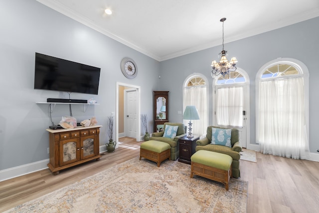 living area featuring an inviting chandelier, ornamental molding, and light hardwood / wood-style floors