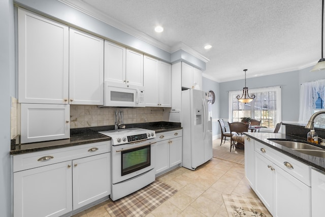 kitchen featuring pendant lighting, sink, white appliances, white cabinets, and decorative backsplash